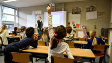 Leerling steekt vinger op in de klas.