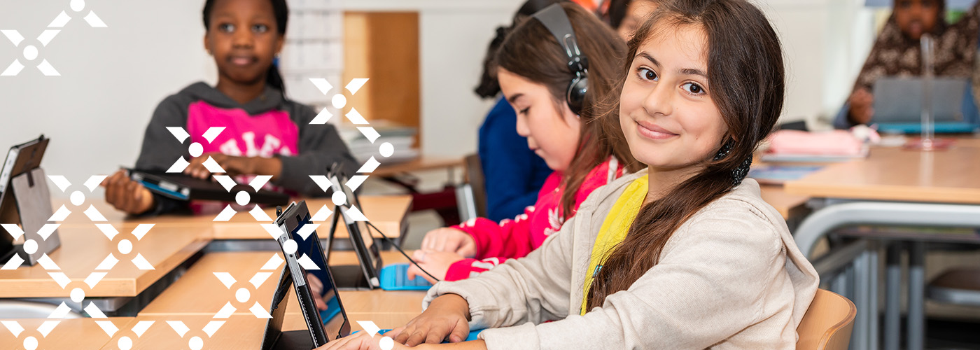 Leerlingen werken in de klas achter hun tablet.