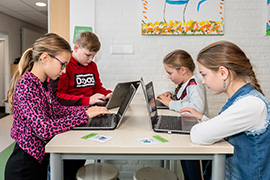Leerlingen werken op laptops op school.