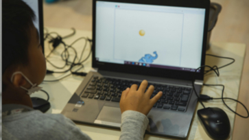 Leerling werkt achter de laptop.