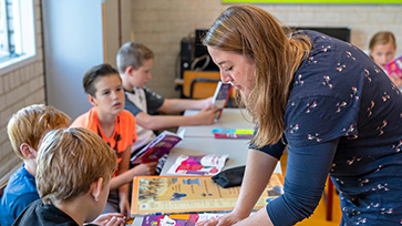 Leraar geeft uitleg aan basisschoolleerlingen in de klas.