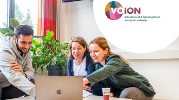 Drie personen zitten samen achter een laptop.