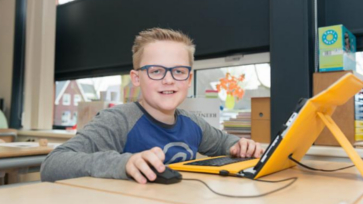 Basisschoolleerling werkt op laptop in de klas.