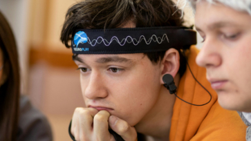 Leerling draagt een neurotechnologie-headset terwijl hij geconcentreerd naar voren kijkt