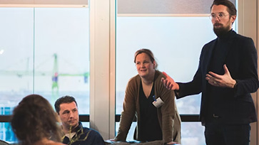 Twee leraren geven uitleg aan andere volwassenen.