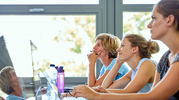 Onderwijsprofessionals kijken aandachtig vooruit.