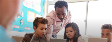 Leraar geeft uitleg aan basisschoolleerlingen in klas.