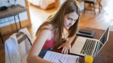 Leerling werkt thuis achter de laptop.